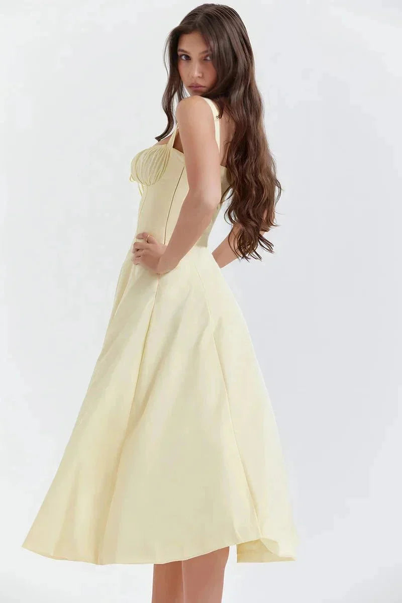 Side view of pale yellow midi dress with fitted bodice and flowing skirt