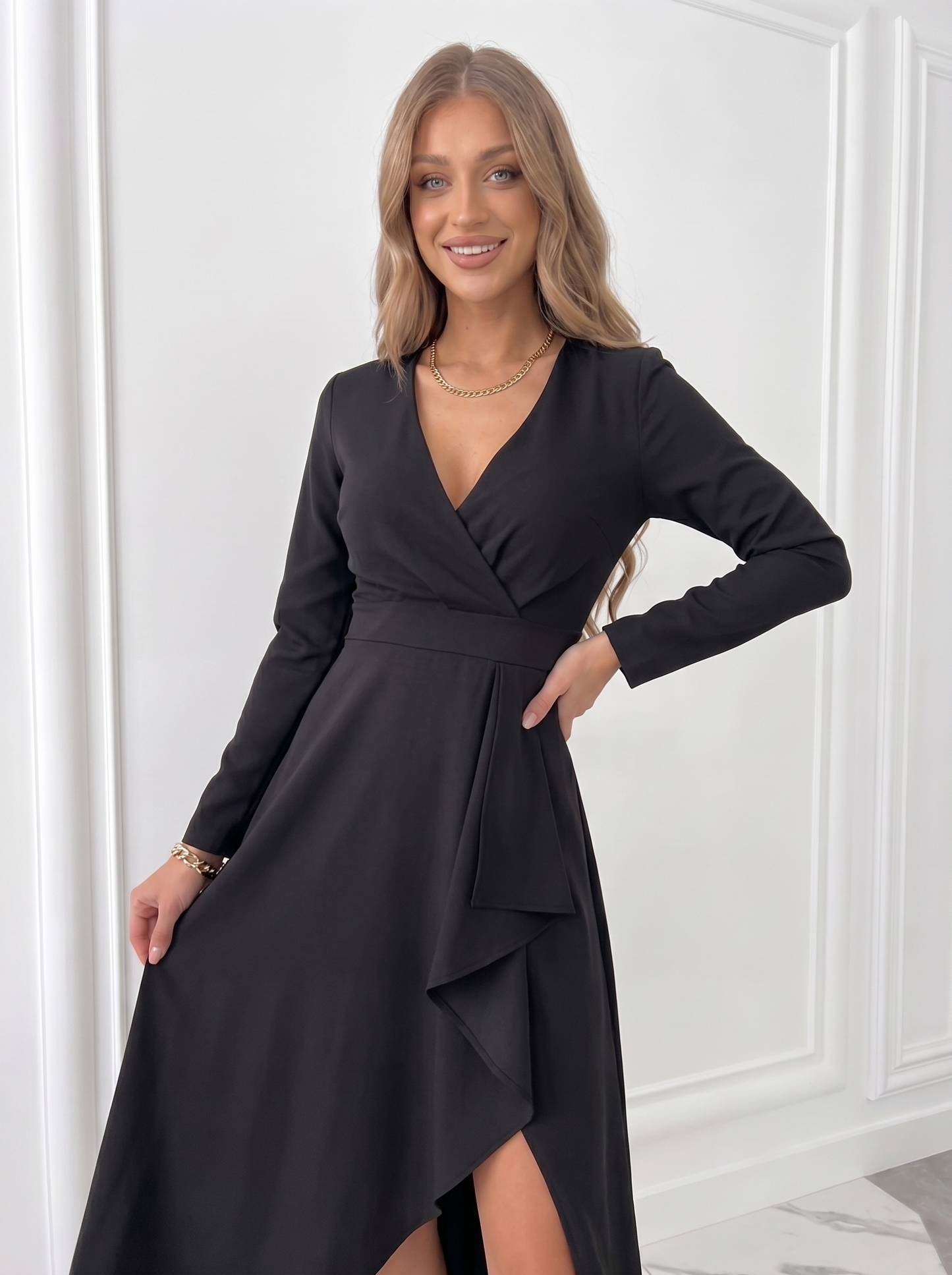 Black midi wedding guest dress with wrap front, long sleeves and elegant draped slit skirt