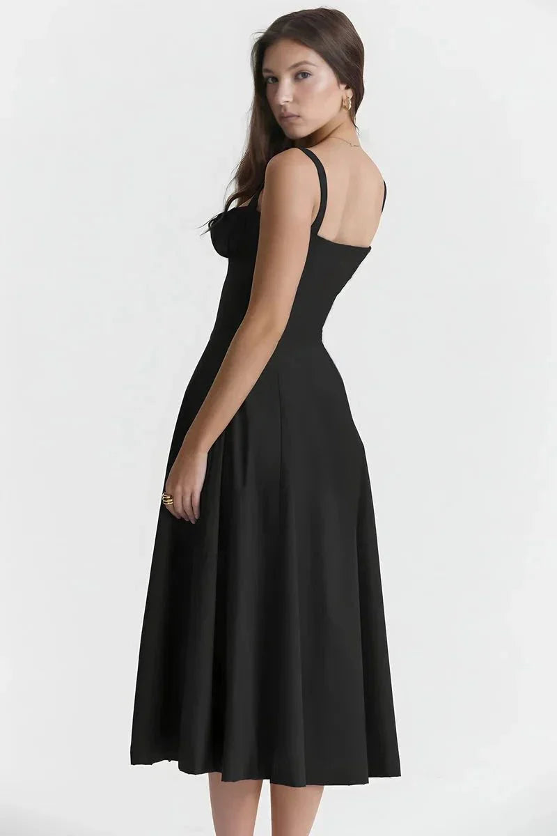 Back view of black spaghetti strap midi dress with fitted waist and flowing skirt