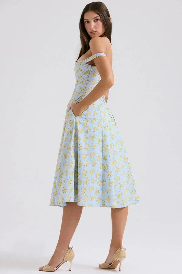 Side back view of floral midi dress showing off shoulder sleeves, fitted waist, and flowing skirt