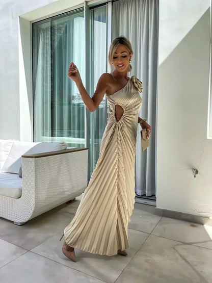 Front view of beige pleated midi dress with one shoulder neckline and flowing skirt
