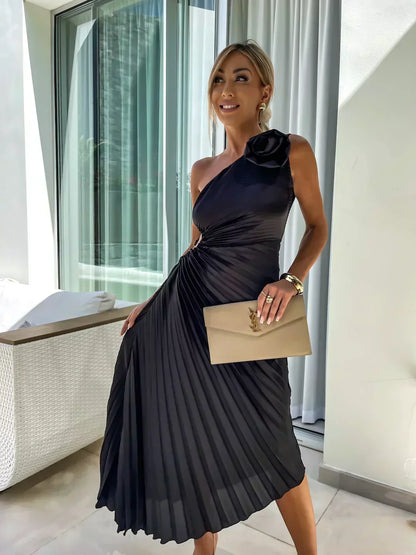 Black one shoulder pleated midi dress with rosette shoulder detail and flowing skirt