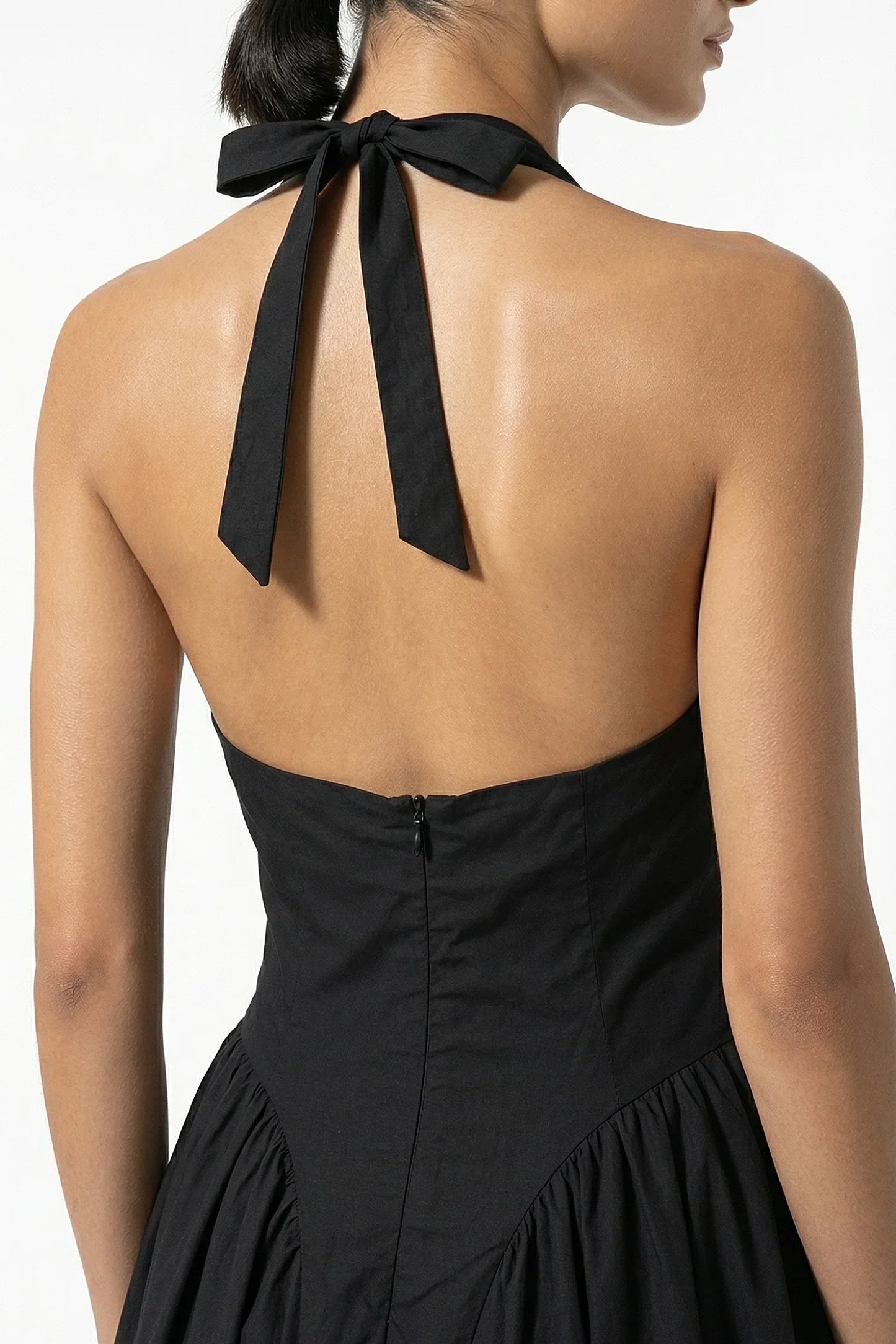 Back view of black halter midi dress with tied neck bow and open back detail