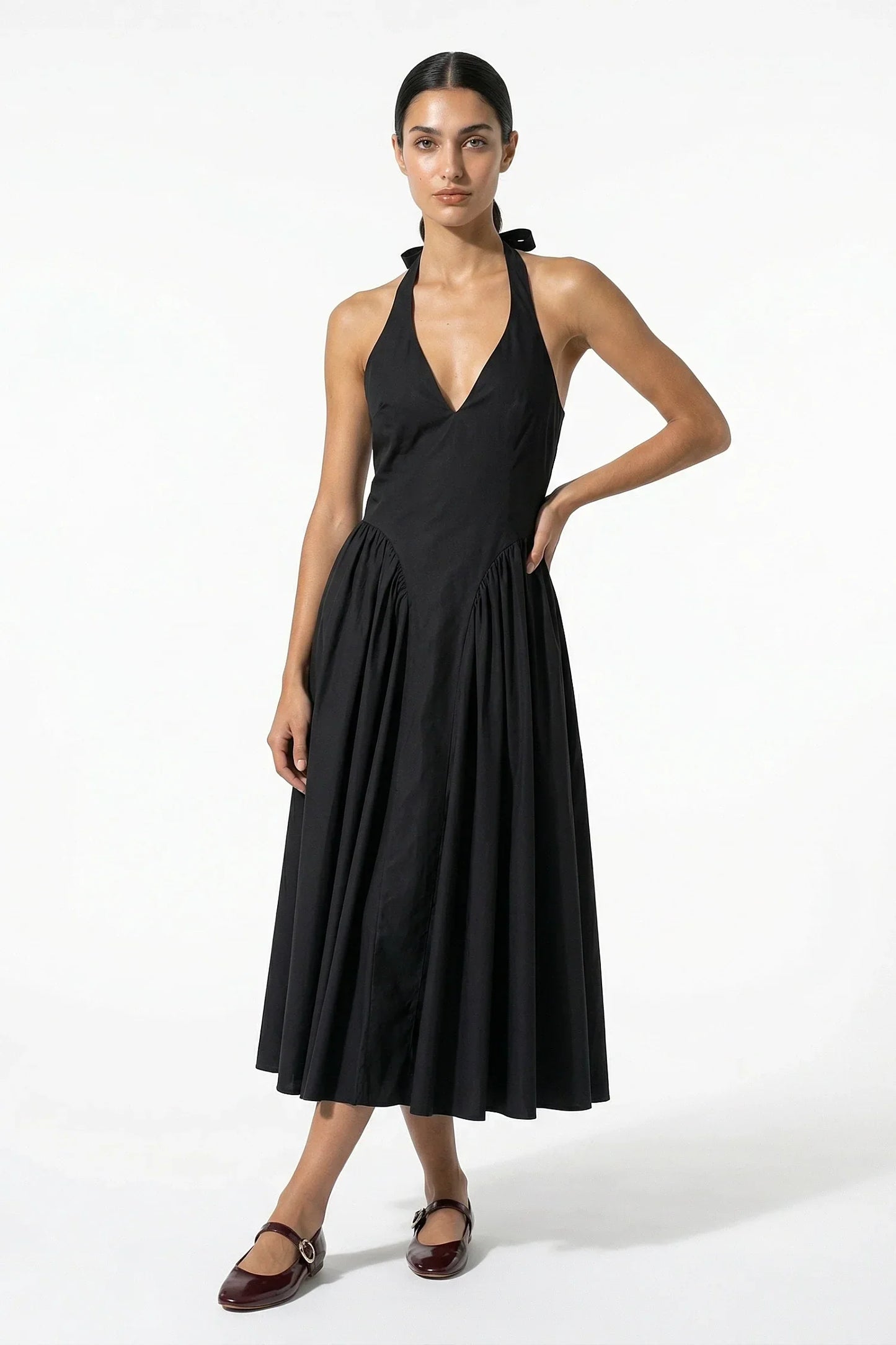 Black halter midi dress with deep V neckline and full pleated skirt, front view