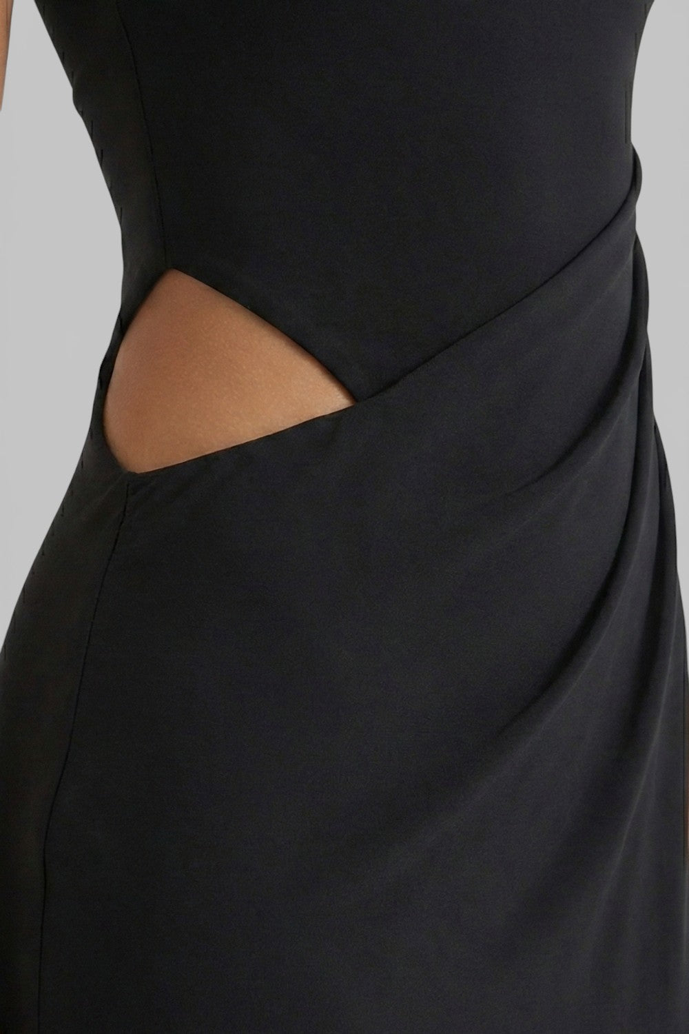 Close-up of black summer maxi dress showing side cut out and draped waist detail