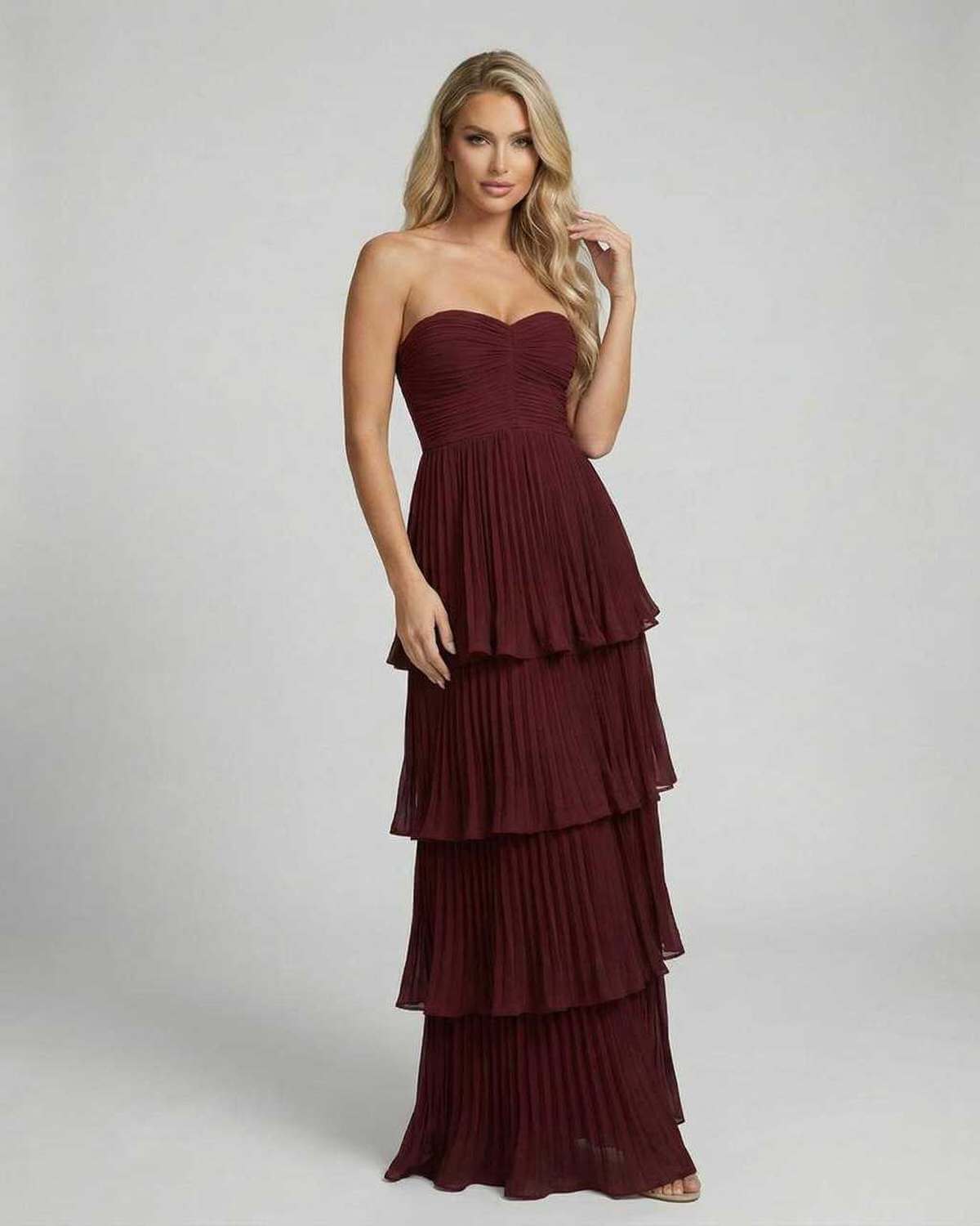 Burgundy strapless maxi dress shown from back with flowing tiered skirt detail