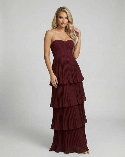 Burgundy strapless maxi dress shown from back with flowing tiered skirt detail