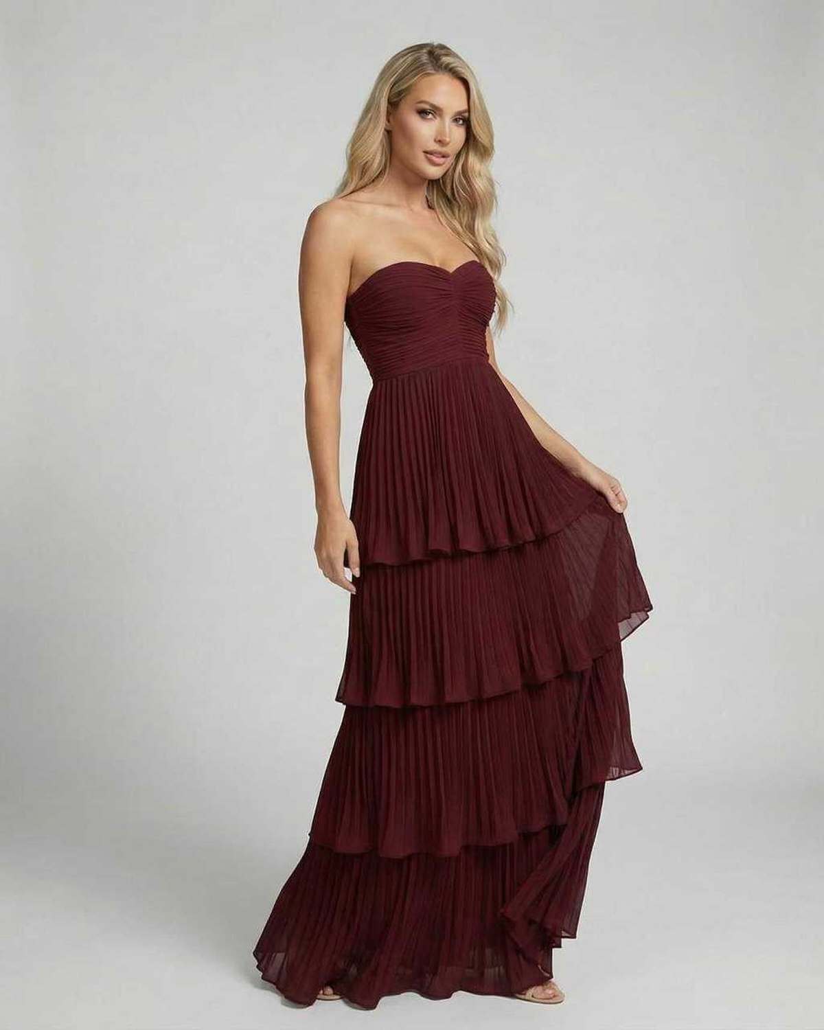 Burgundy strapless wedding guest dress with fitted bodice and tiered maxi hem