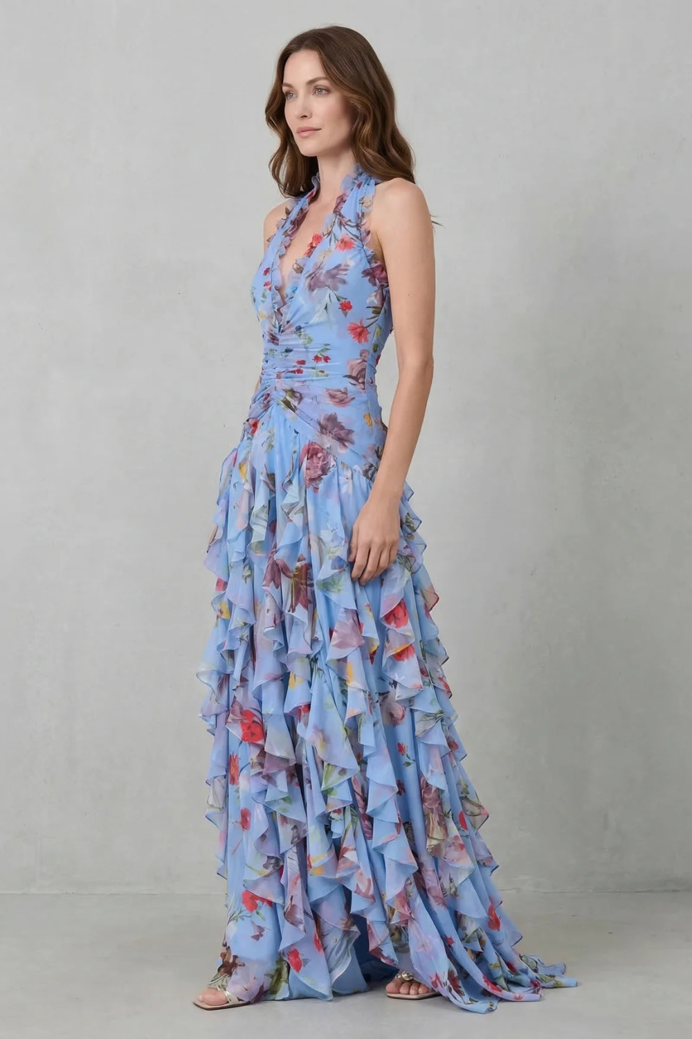 Side view of blue floral halter maxi dress with layered ruffles and floor-length hem