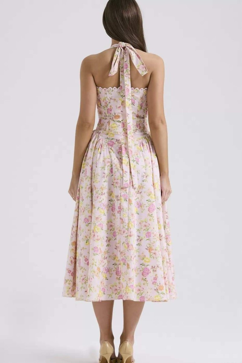 Back view of floral halter midi dress with tie neck, smocked back, and flowing skirt