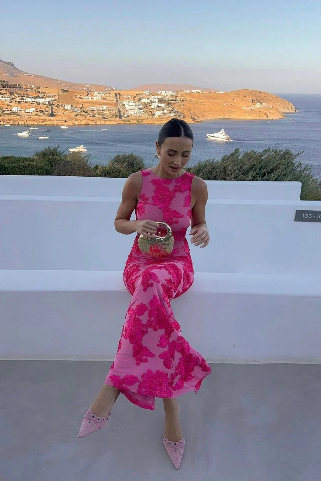 Pink floral maxi dress worn with pointed heels, showing flowing hem and sheer fabric