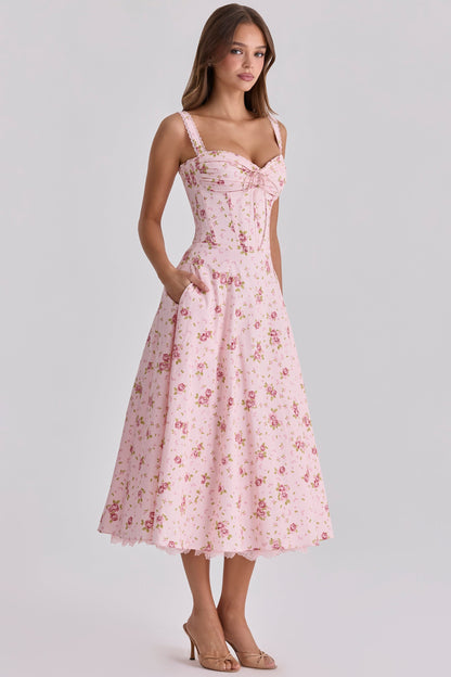 Three-quarter front view of pink floral wedding guest dress with fitted waist and midi length