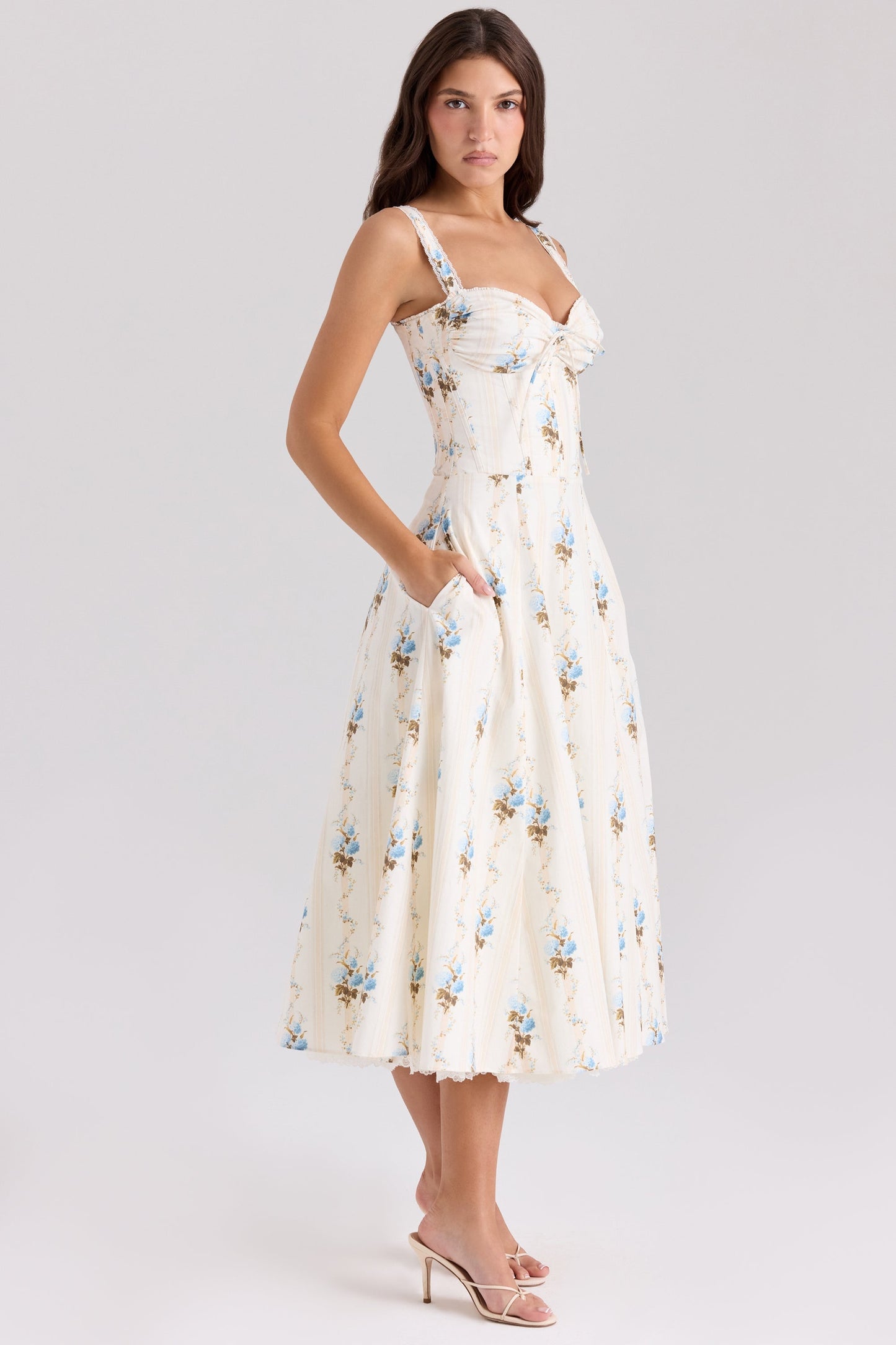 Three-quarter back view of cream floral midi dress with fitted bodice and flared skirt