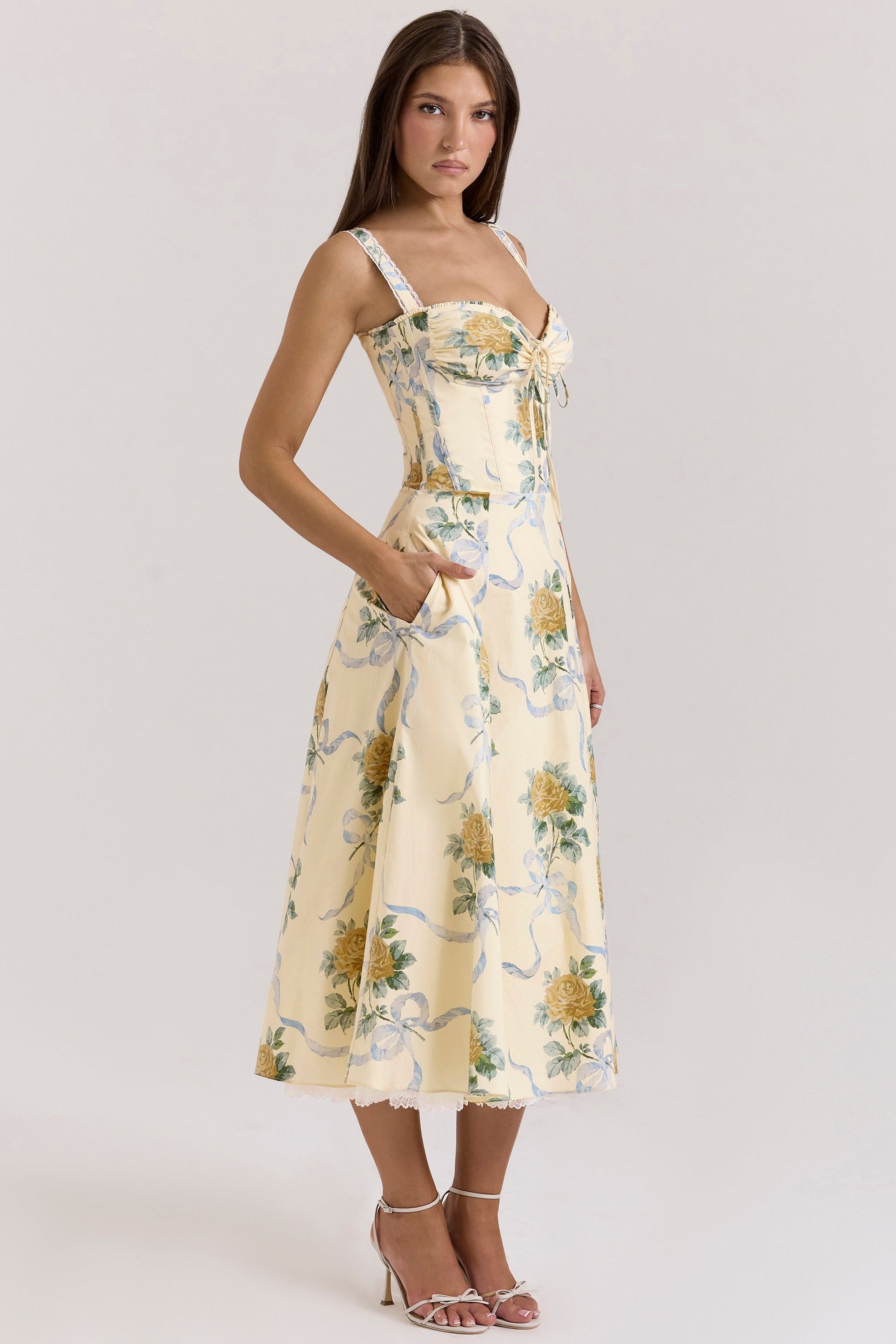 Back view of cream floral midi dress with lace straps, zipper closure, and full skirt