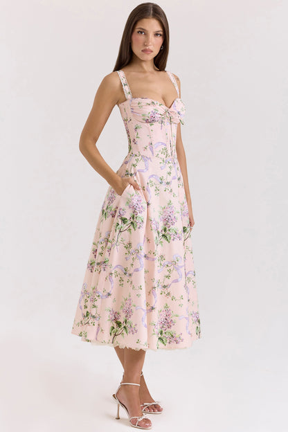 Side front view of pink floral wedding guest midi dress with fitted corset waist