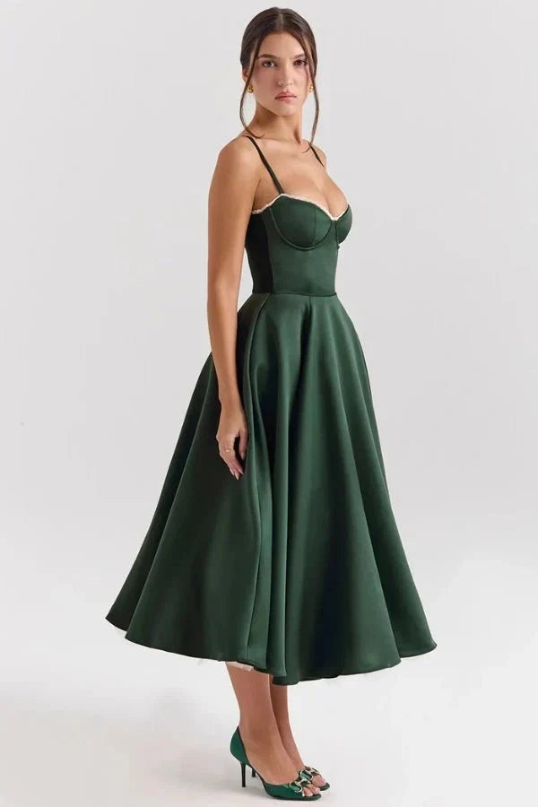 Side view of dark green midi dress showing open back, fitted waist, and flowing skirt