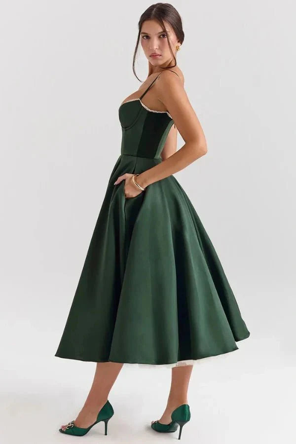 Back angled view of dark green midi wedding guest dress with open back and full skirt
