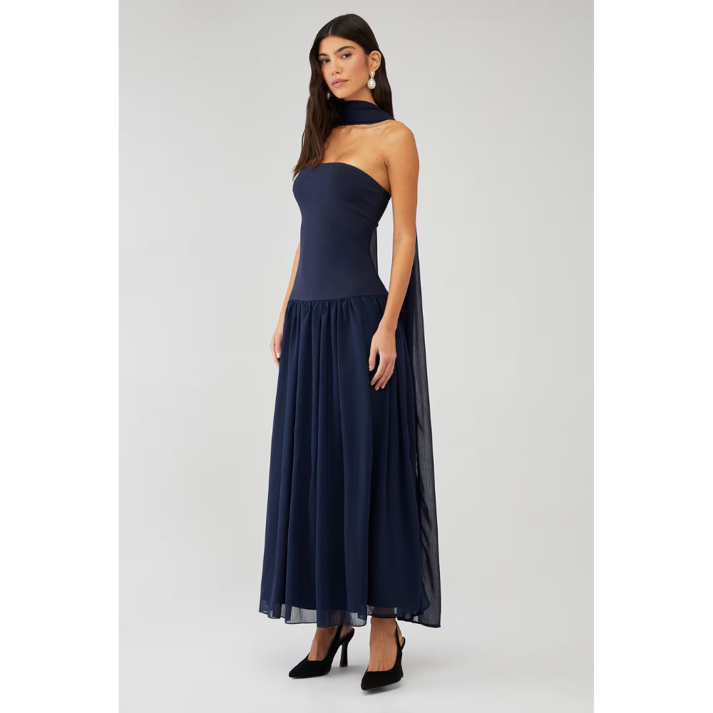 Front angled view of navy strapless maxi dress with flowing chiffon skirt